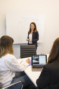 Marketing consultant discussing digital marketing trends work meeting women with white board team discussion writing on whiteboard group presentation meeting workspace