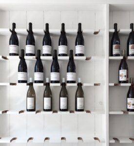 Wall of wine bottles for purple giraffe blog on benefits of a wine club