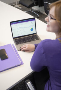 Email marketing at purple giraffe, lady pointing at computer statistics